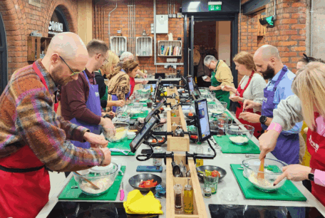 Attendees preparing ingredients at their workstations during a Curry Club cookery class.Attendees preparing ingredients at their individual workstations during a Curry Club cookery class.