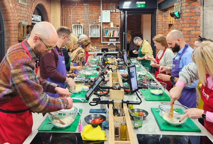 Attendees preparing ingredients at their workstations during a Curry Club cookery class.Attendees preparing ingredients at their individual workstations during a Curry Club cookery class.